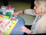 Mary Neves celebrates her 100th birthday by cutting her cake.
